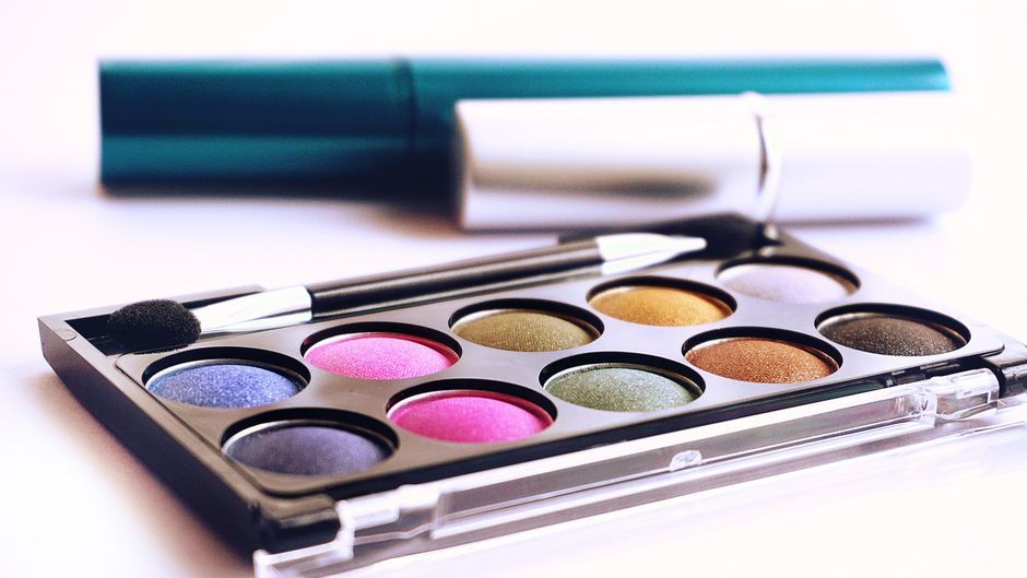 Produits de maquillage colorés alignés sur une surface