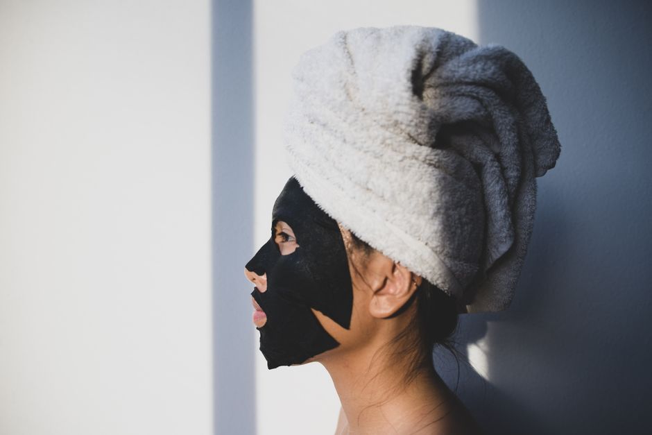 Femme appliquant un masque cosmétique sur le visage