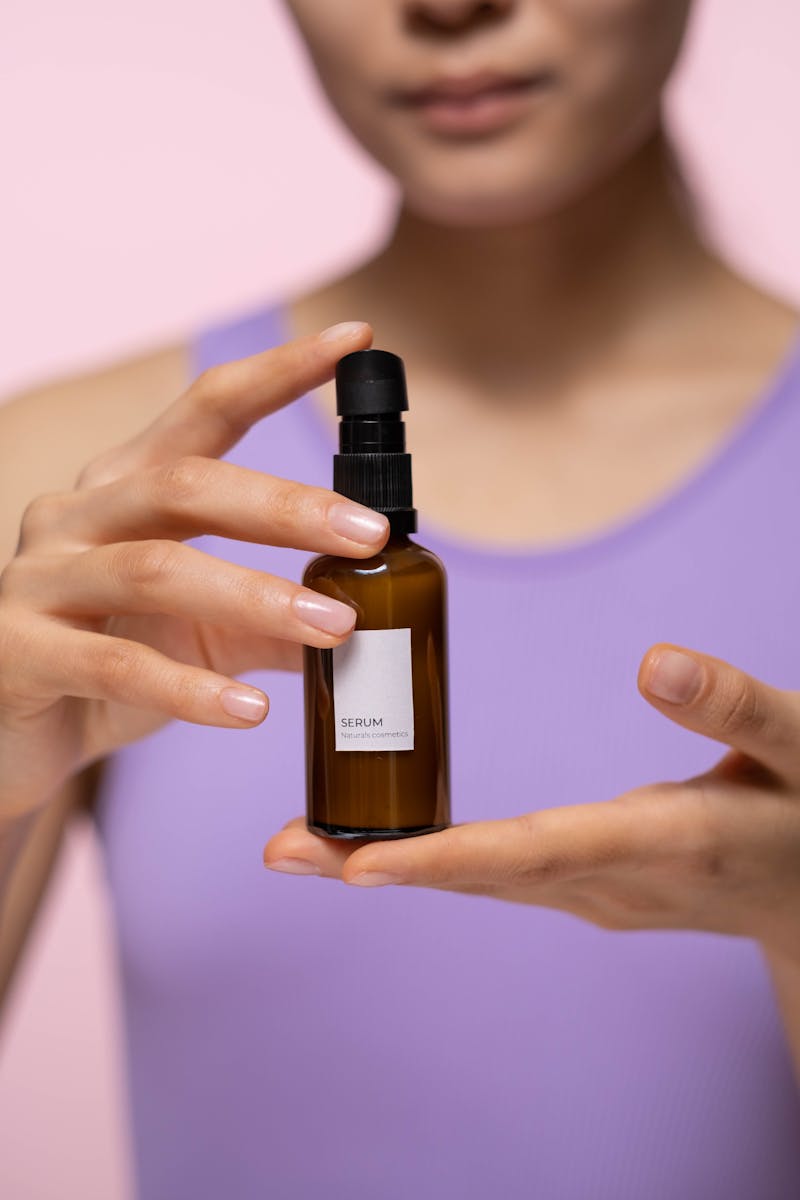 Sérum en flacon brun tenu entre les mains