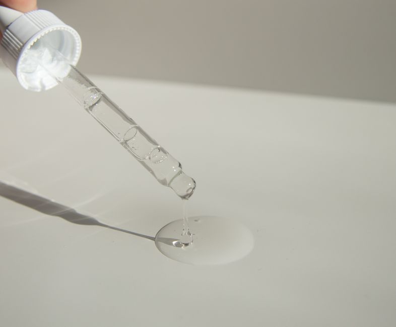 Goutte d'eau sur une texture de sérum cosmétique transparent
