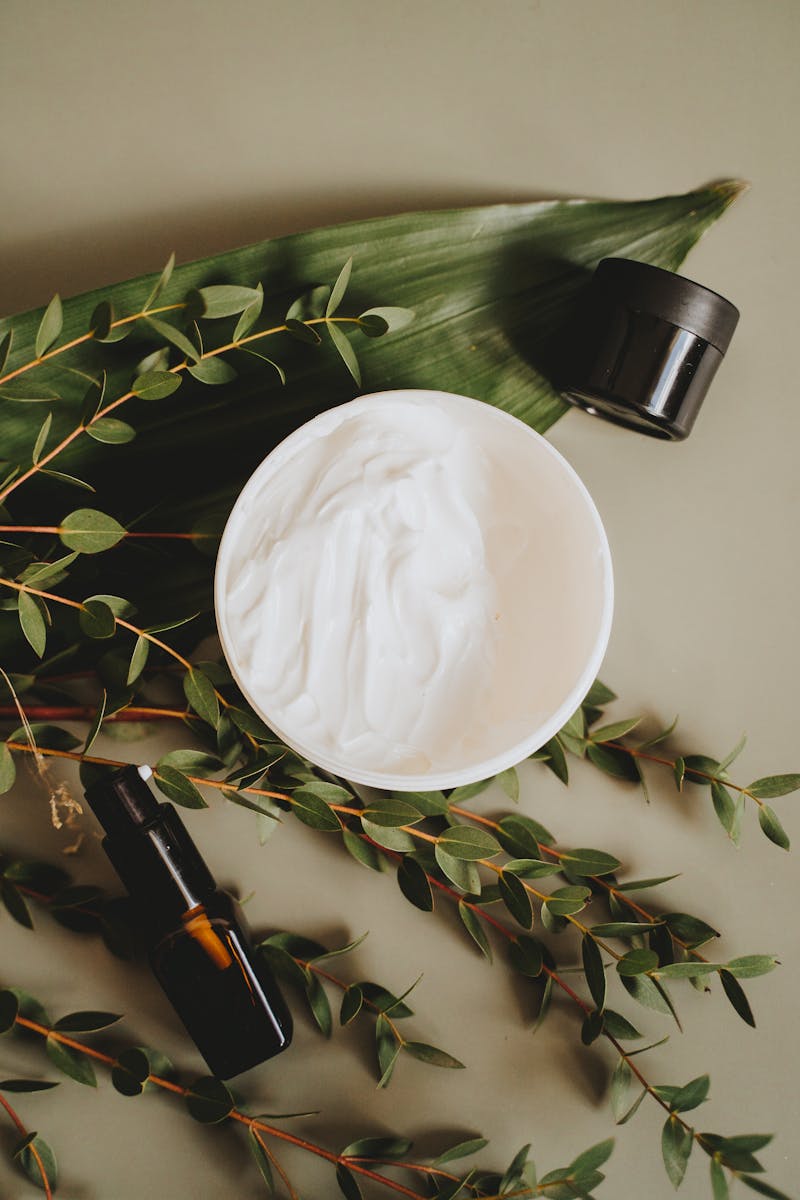 Soin cosmétique entouré de feuilles botaniques